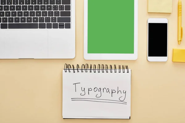 Pose plate avec gadgets et typographie lettrage dans le bloc-notes sur fond jaune — Photo de stock