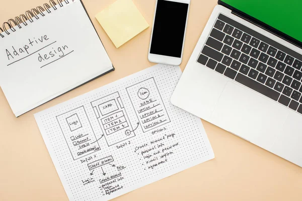 Vue du haut des gadgets près du modèle de conception de site Web et ordinateur portable avec lettrage de conception adaptative sur fond beige — Photo de stock