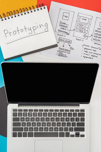 Top view of notebook with prototyping lettering, laptop and website design template on abstract geometric background — Stock Photo