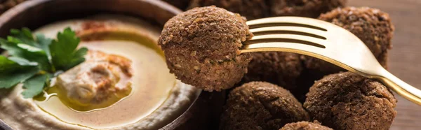 Hummus and falafel served on wooden table with fork, panoramic shot — Stock Photo