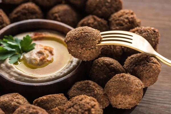 Hummus e falafel serviti su tavolo in legno con forchetta — Foto stock