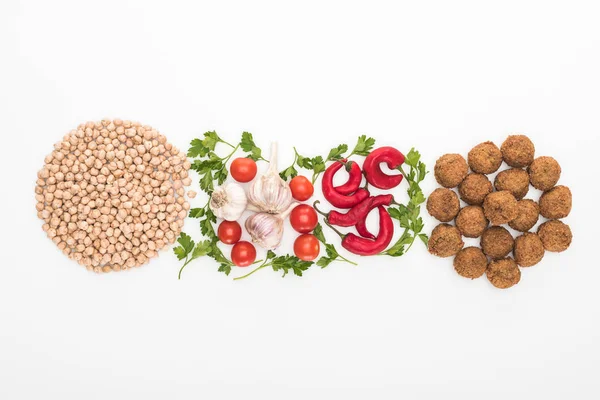 Vue du haut du pois chiche, ail, tomates cerises, persil, piment et falafel sur fond blanc — Photo de stock