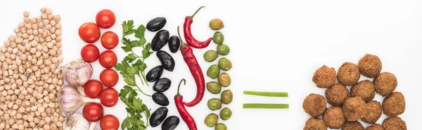 Top view of chickpea, garlic, cherry tomatoes, parsley, olives, chili pepper, green onion and falafel on white background, panoramic shot — Stock Photo