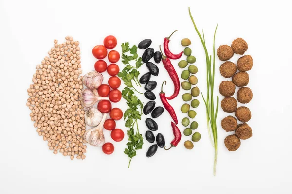 Blick von oben auf Kichererbsen, Knoblauch, Kirschtomaten, Petersilie, Oliven, Chili, grüne Zwiebel und Falafel auf weißem Hintergrund — Stockfoto