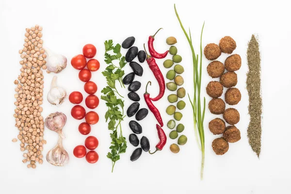 Top view of chickpea, garlic, cherry tomatoes, parsley, olives, chili pepper, green onion, herb and falafel on white background — Stock Photo