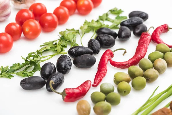 Close up view of cherry tomatoes, parsley, olives, chili pepper on white background — Stock Photo