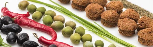 Vista ravvicinata di prezzemolo, olive, peperoncino, cipolla verde, erba e falafel su sfondo bianco, colpo panoramico — Foto stock