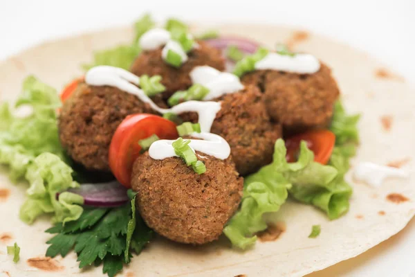 Vue rapprochée des boules de falafel fraîches sur pita avec légumes et sauce sur fond blanc — Photo de stock