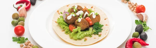 Gemüse in rundem Rahmen um Falafel auf Pita auf Teller auf weißem Hintergrund angeordnet, Panoramaaufnahme — Stockfoto