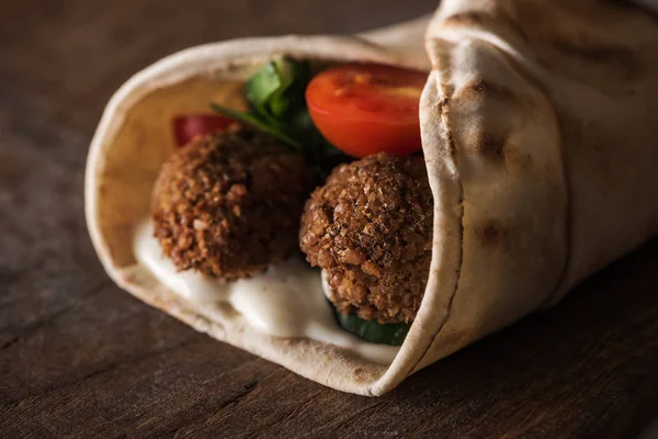 Primer plano vista de falafel con salsa y verduras en pita - foto de stock