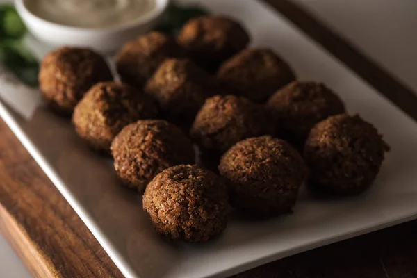 Vista de perto de bolas de falafel na placa branca com molho — Fotografia de Stock