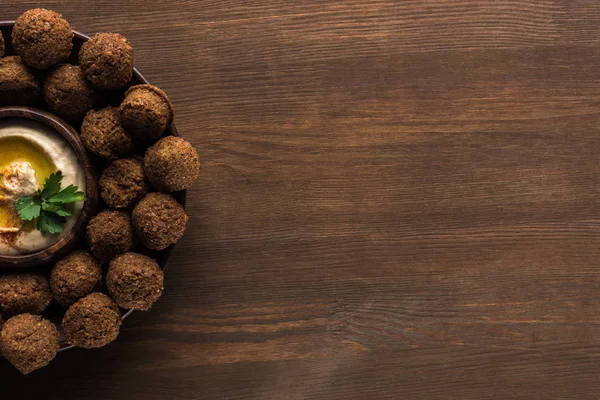 Top view of falafel balls with hummus on plate on wooden table with copy space — Stock Photo