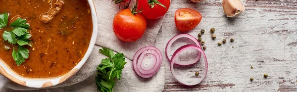 Blick von oben auf georgische Suppe kharcho mit Koriander und Gemüse auf dem Tisch, Panoramaaufnahme — Stockfoto