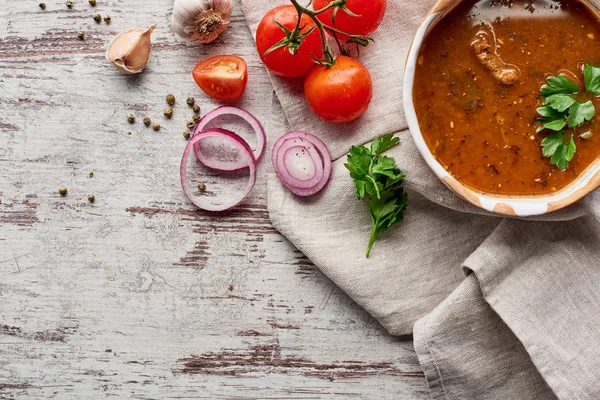 Blick von oben auf georgische Suppe kharcho mit Koriander und Gemüse auf Holztisch — Stockfoto