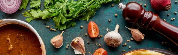 Draufsicht auf Suppe kharcho mit Gewürzen und Gemüse auf texturiertem grünem Hintergrund, Panoramaaufnahme — Stockfoto