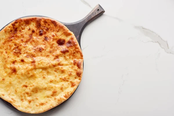 Top view of traditional imereti khachapuri on chopping board on marble texture — Stock Photo