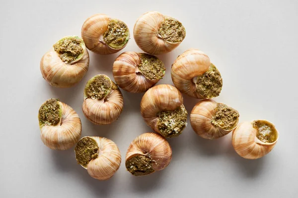 Vue de dessus de délicieux escargots cuits sur fond blanc — Photo de stock