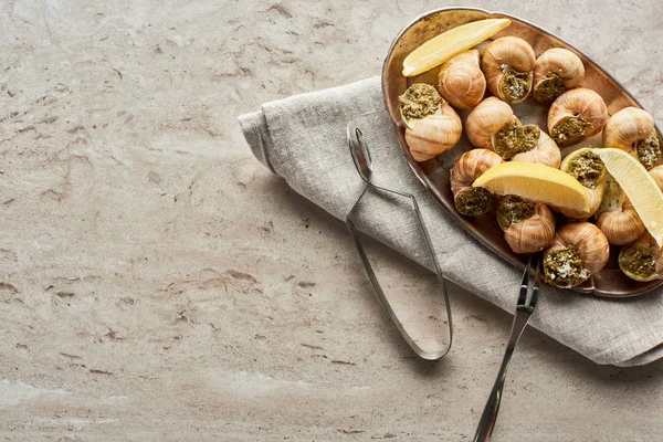 Vista superior de deliciosas escargotas servidas com limão no fundo de pedra — Fotografia de Stock