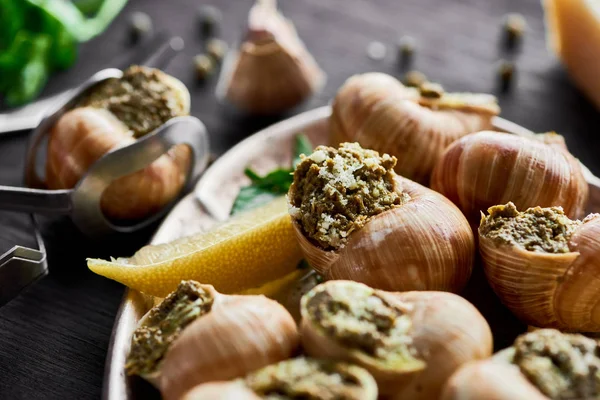Vue rapprochée de délicieux escargots cuits avec des tranches de citron — Photo de stock