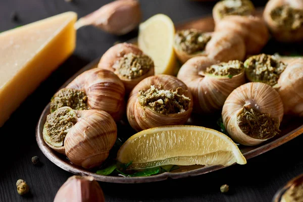 Vue rapprochée de délicieux escargots cuits avec des tranches de citron — Photo de stock