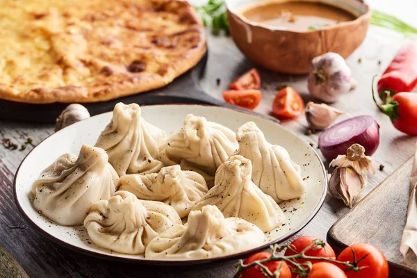 Foco seletivo de Imeretian khachapuri, kharcho e khinkali na mesa de madeira — Fotografia de Stock