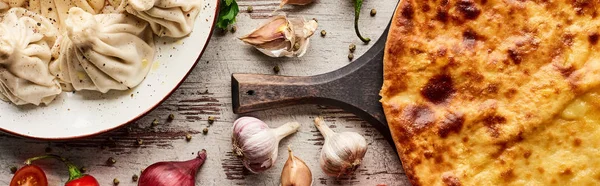 Top view of delicious khinkali near Imeretian khachapuri wooden table, panoramic shot — Stock Photo