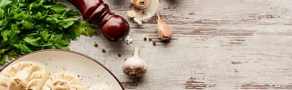 Vue du dessus de délicieux khinkali près des légumes et des épices sur une table en bois, vue panoramique — Photo de stock