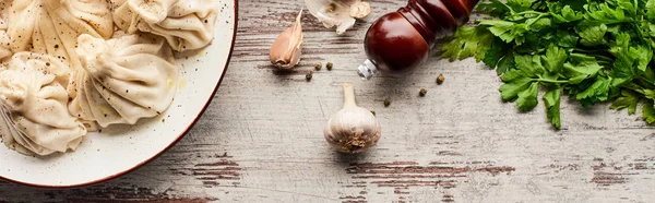 Vue du dessus de délicieux khinkali près des légumes et des épices sur la table en bois — Photo de stock