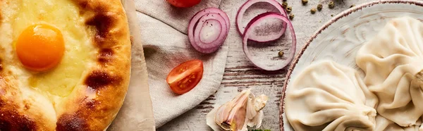 Vue du dessus de délicieux khinkali près de adjarian khachapuri sur table en bois, vue panoramique — Photo de stock