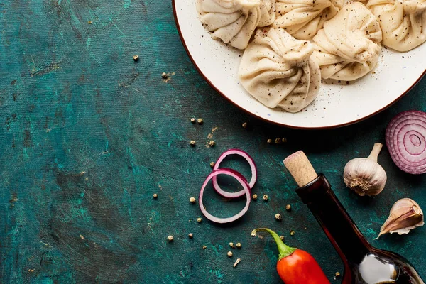 Vista superior de khinkali delicioso e vinho com especiarias no fundo verde — Fotografia de Stock