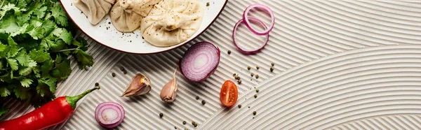 Top view of delicious khinkali near vegetables and spices on beige textured background, panoramic shot — Stock Photo