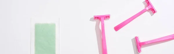 Top view of female pink razors and depilation stripe on white background, panoramic shot — Stock Photo