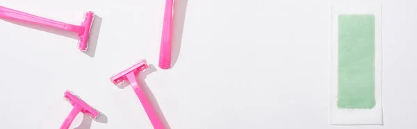 Top view of female pink razors and depilation stripe on white background, panoramic shot — Stock Photo