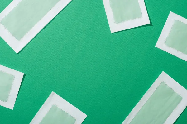 Top view of depilation wax stripes on green background — Stock Photo