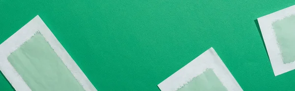 Top view of green depilation wax stripes on green background, panoramic shot — Stock Photo