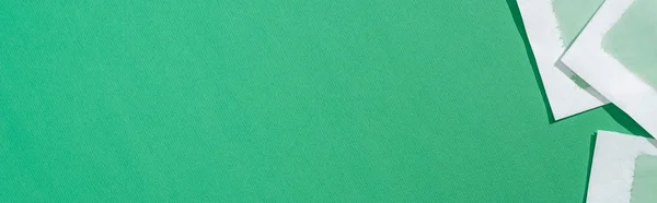 Вид зверху на депіляційні воскові смуги на зеленому фоні з копіювальним простором, панорамний знімок — стокове фото