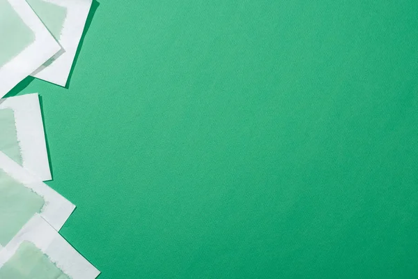 Vista superior de franjas de cera de depilación verde sobre fondo verde con espacio de copia - foto de stock
