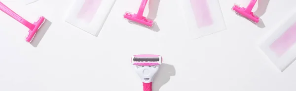 Top view of pink razors and depilation wax stripes on white background, panoramic shot — Stock Photo