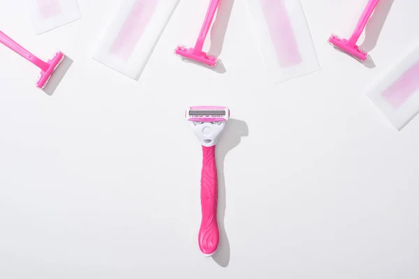 Top view of pink razors and depilation wax stripes on white background — Stock Photo