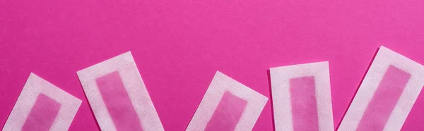 Top view of wax depilation stripes on pink background, panoramic shot — Stock Photo