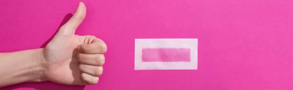 Cropped view of woman showing thumb up near depilation wax stripe on pink background, panoramic shot — Stock Photo
