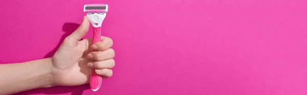 Recortado vista de la mujer sosteniendo la navaja sobre fondo rosa, plano panorámico - foto de stock