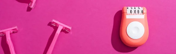 Top view of disposable razors, epilator on pink background, panoramic shot — Stock Photo