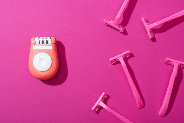 Top view of disposable razors, epilator on pink background — Stock Photo
