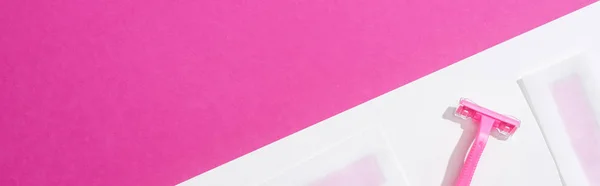 Top view of disposable razor and wax depilation stripes on white and pink background, panoramic shot — Stock Photo