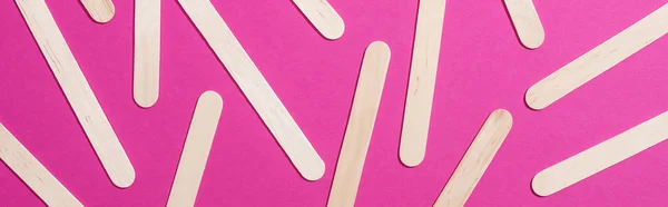 Top view of depilation wooden sticks on pink background, panoramic shot — Stock Photo