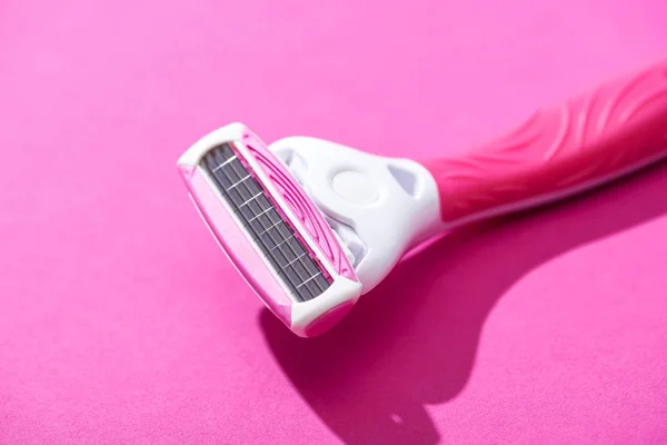 Vista de cerca de la maquinilla de afeitar sobre fondo rosa - foto de stock