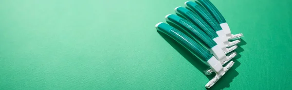 Disposable razors on green background with copy space, panoramic shot — Stock Photo