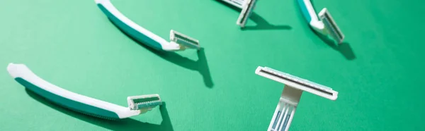 Selective focus of disposable razors on green background, panoramic shot — Stock Photo