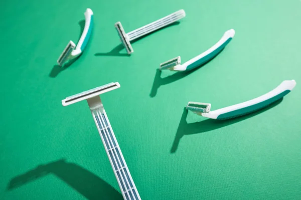 Selective focus of disposable razors on green background — Stock Photo